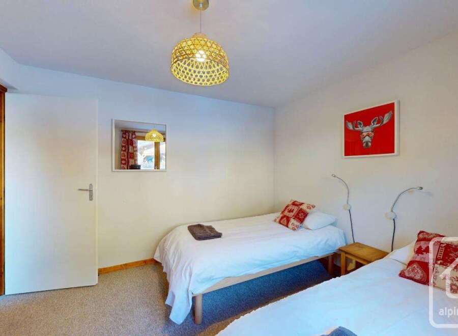 Cozy twin bedroom with wooden floors and a warm atmosphere.