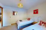 Cozy twin bedroom with wooden floors and a warm atmosphere.
