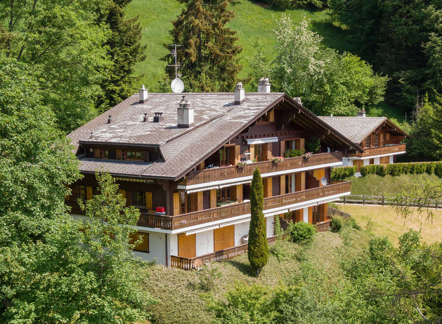 Nestled amidst lush greenery, this stunning property boasts a classic chalet design.