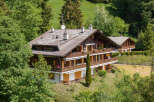 Nestled amidst lush greenery, this stunning property boasts a classic chalet design.