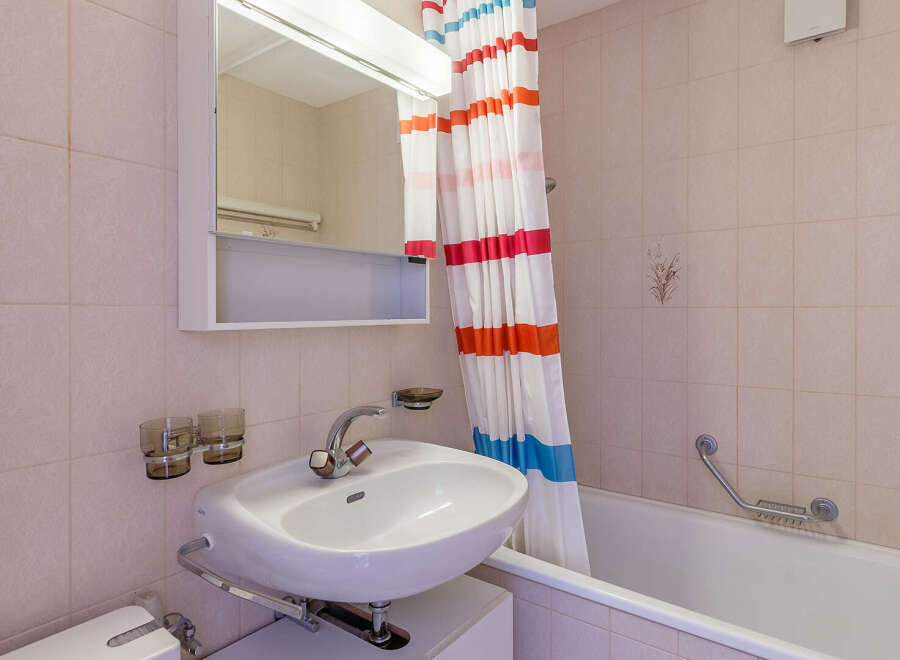 This charming bathroom features a classic design with tiled walls and a functional layout.