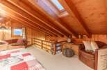 This cozy attic space features a warm wooden interior and a skylight that floods the room with natural light.