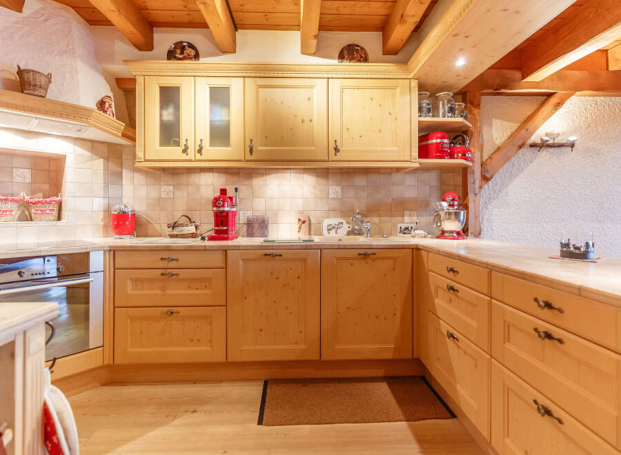 This charming kitchen boasts a warm, inviting atmosphere with its natural wood cabinetry and exposed beams.