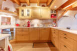 This charming kitchen boasts a warm, inviting atmosphere with its natural wood cabinetry and exposed beams.