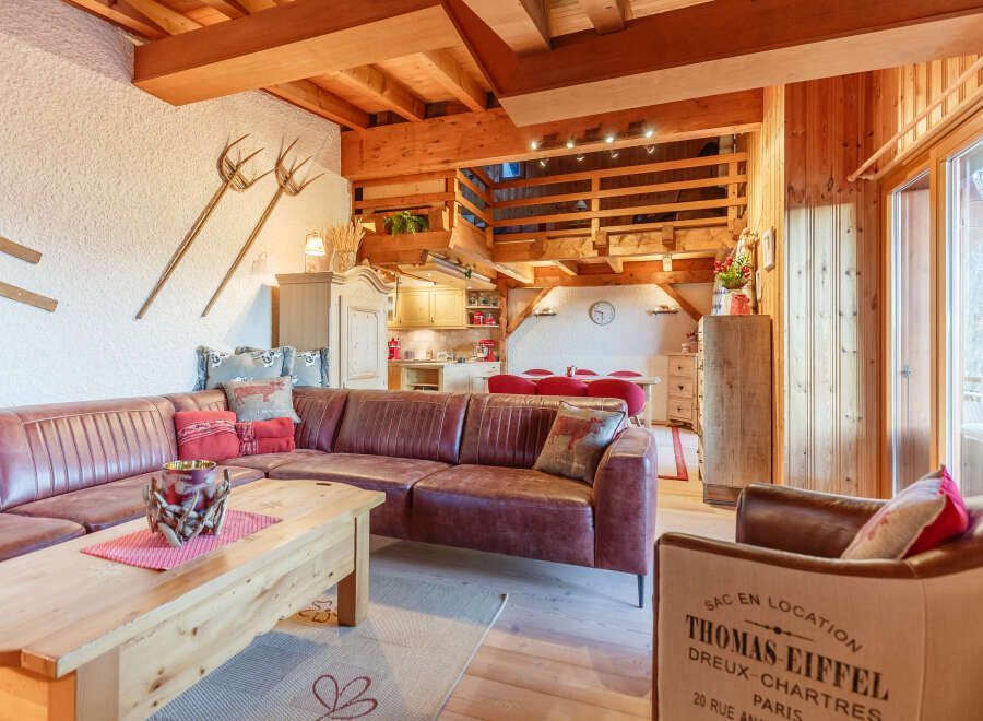 This cozy living space features a rustic design with exposed wooden beams and a warm, inviting atmosphere.
