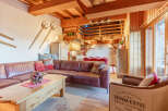 This cozy living space features a rustic design with exposed wooden beams and a warm, inviting atmosphere.