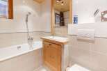This charming bathroom features a cozy wooden ceiling and a stylish wooden vanity.