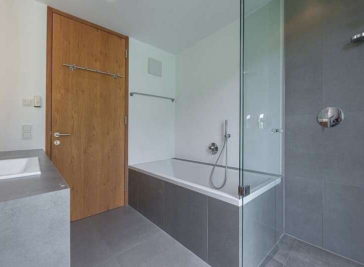 Modern bathroom design featuring a sleek glass shower enclosure and a luxurious bathtub.