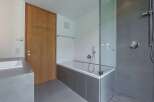 Modern bathroom design featuring a sleek glass shower enclosure and a luxurious bathtub.