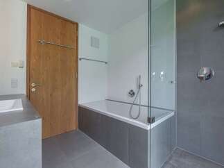 Modern bathroom design featuring a sleek glass shower enclosure and a luxurious bathtub.