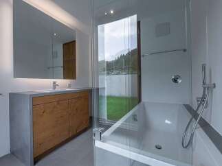 This modern bathroom boasts a sleek design with a combination of wood and concrete elements.
