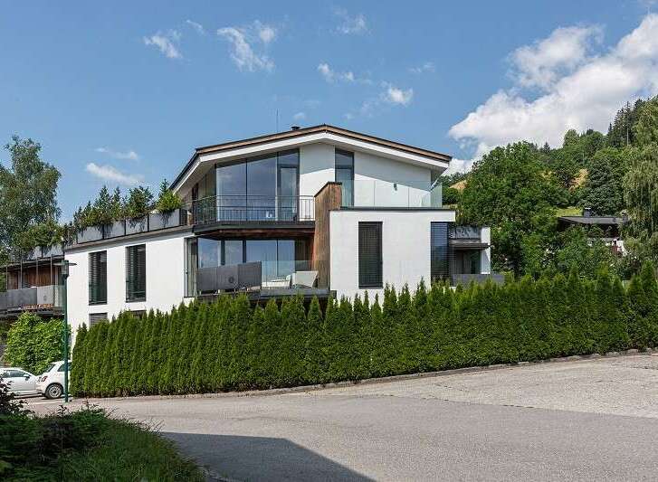 Discover modern luxury in this stunning property, featuring a sleek white exterior and expansive glass windows that flood the interiors with natural light.