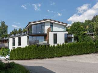 Discover modern luxury in this stunning property, featuring a sleek white exterior and expansive glass windows that flood the interiors with natural light.