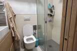 This modern bathroom features a sleek, minimalist design with a walk-in shower and a contemporary toilet.