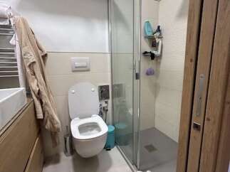 This modern bathroom features a sleek, minimalist design with a walk-in shower and a contemporary toilet.