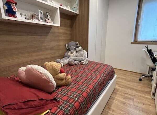 Cozy bedroom with a comfortable bed featuring a vibrant plaid pattern.