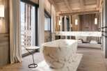 Luxurious bathroom with marble bathtub and wooden accents.