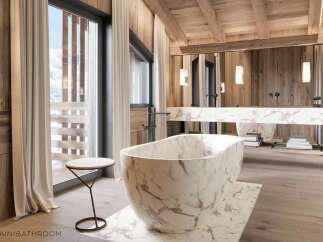Luxurious bathroom with marble bathtub and wooden accents.