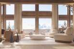 Luxurious chalet living room with floor-to-ceiling windows offering breathtaking mountain views.