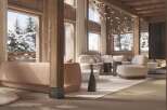This stunning chalet boasts a spacious salon/living room with floor-to-ceiling windows offering breathtaking views of the snowy landscape.