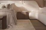 Relax in this serene bedroom, featuring a plush curved sofa and a cozy bed with soft linens.
