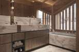 Luxurious bathroom with marble finishes and wooden accents.