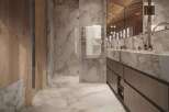 Luxurious bathroom with marble flooring and walls, wooden accents, and a double vanity.