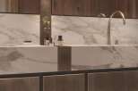 Luxury bathroom boasts a stunning marble countertop with sleek, modern faucets.