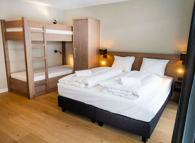 This cozy bedroom features a comfortable double bed and a bunk bed, perfect for families or groups.