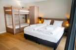 This cozy bedroom features a comfortable double bed and a bunk bed, perfect for families or groups.