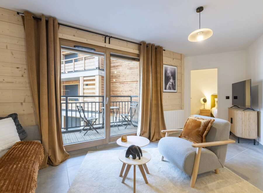 Experience the charm of this cozy living space, featuring a stylish armchair and a plush rug.