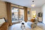 Experience the charm of this cozy living space, featuring a stylish armchair and a plush rug.