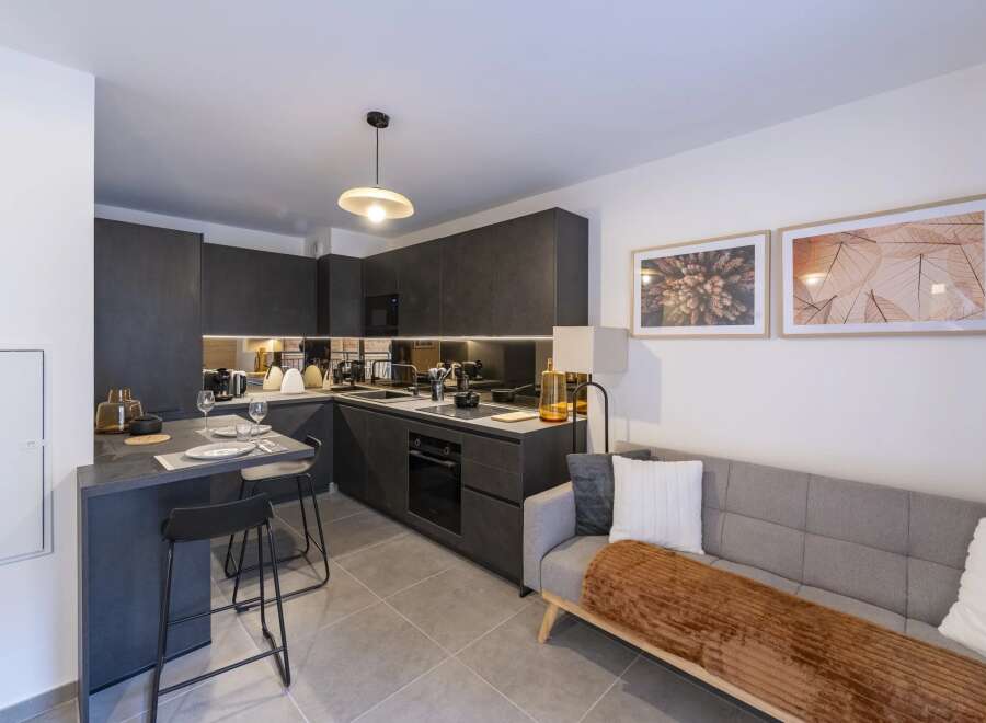 This modern kitchen and living space offers a sleek and stylish design, perfect for contemporary living.