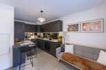 This modern kitchen and living space offers a sleek and stylish design, perfect for contemporary living.
