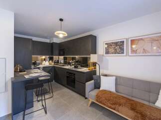 This modern kitchen and living space offers a sleek and stylish design, perfect for contemporary living.