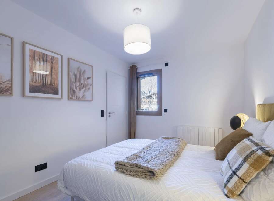 This cozy bedroom offers a serene retreat with its neutral color palette and inviting ambiance.
