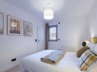 This cozy bedroom offers a serene retreat with its neutral color palette and inviting ambiance.