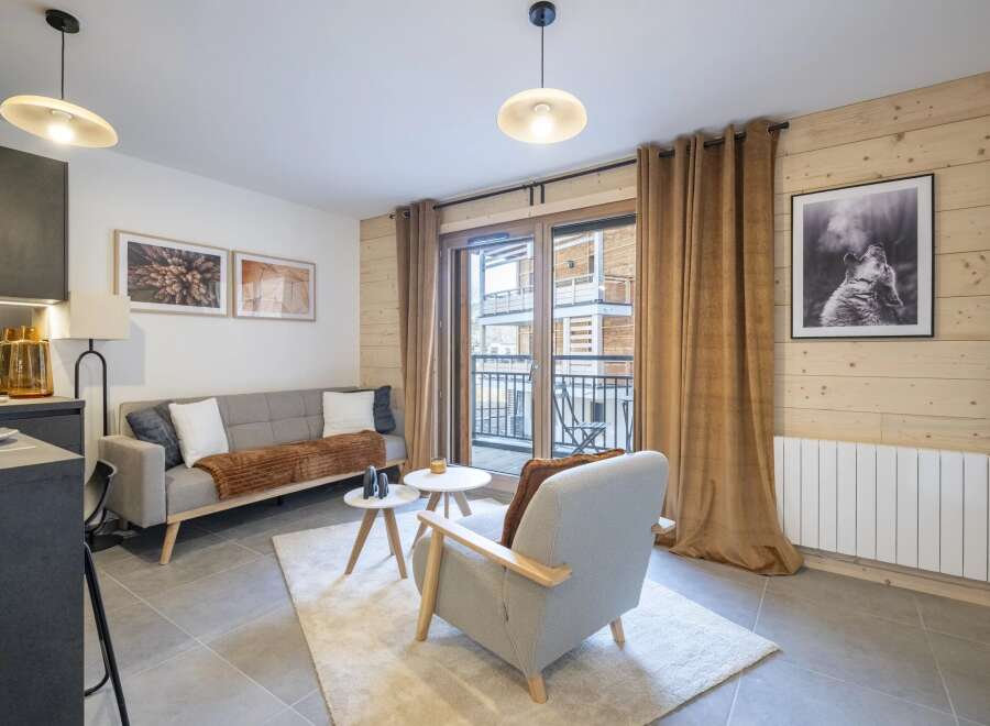 This cozy living space features a comfortable sofa, a stylish armchair, and two elegant side tables.