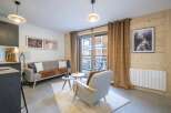 This cozy living space features a comfortable sofa, a stylish armchair, and two elegant side tables.