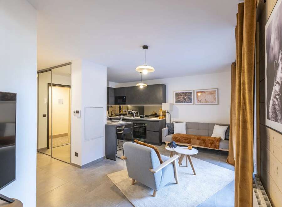 Discover modern living in this stylish apartment, featuring a sleek kitchen and a cozy living area.