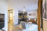 Discover modern living in this stylish apartment, featuring a sleek kitchen and a cozy living area.