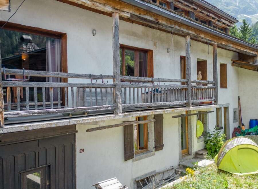 Discover the charm of this rustic mountain home, featuring a traditional wooden balcony and shutters.