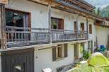 Discover the charm of this rustic mountain home, featuring a traditional wooden balcony and shutters.