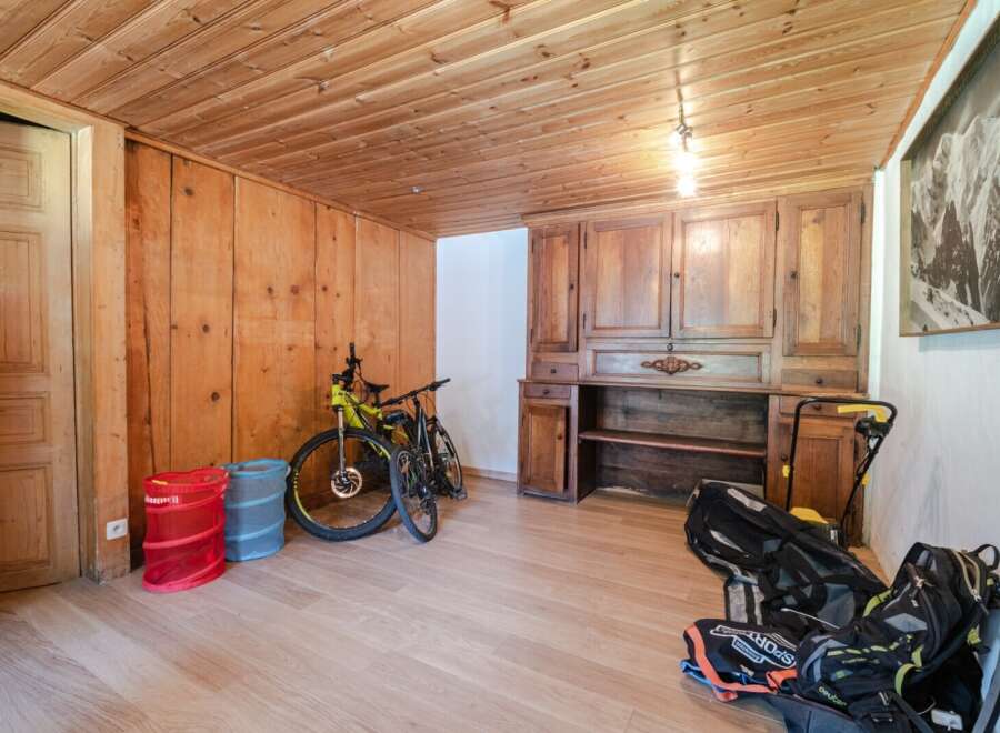 This charming property boasts a warm and inviting interior with wooden paneling and flooring throughout.