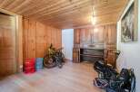 This charming property boasts a warm and inviting interior with wooden paneling and flooring throughout.