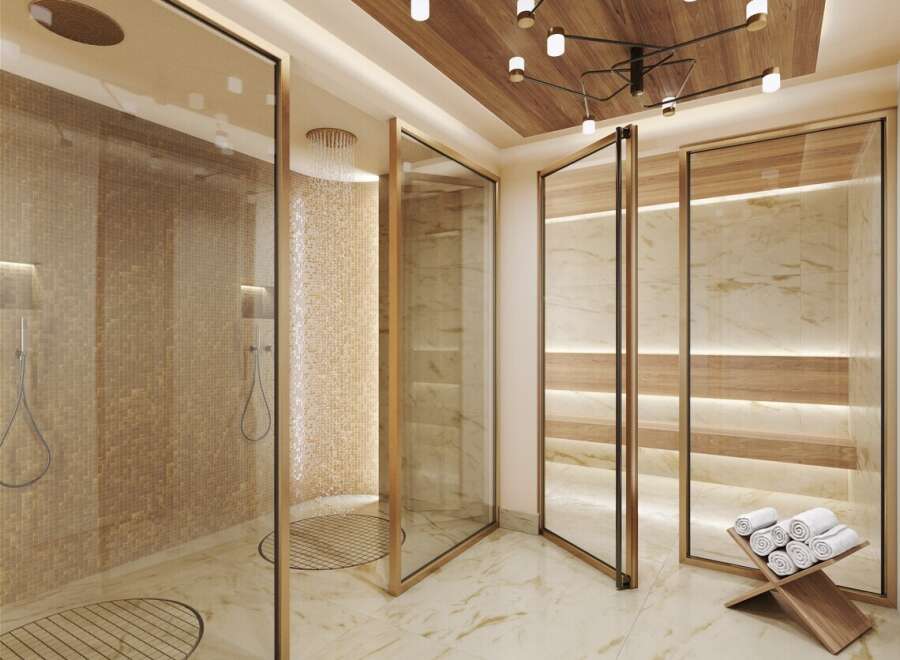 Indulge in luxury within this spa-like bathroom, featuring multiple glass-enclosed showers with elegant gold framing.