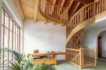 This stunning property boasts a grand, curved wooden staircase that is both functional and visually striking.