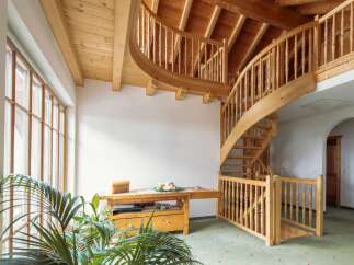 This stunning property boasts a grand, curved wooden staircase that is both functional and visually striking.