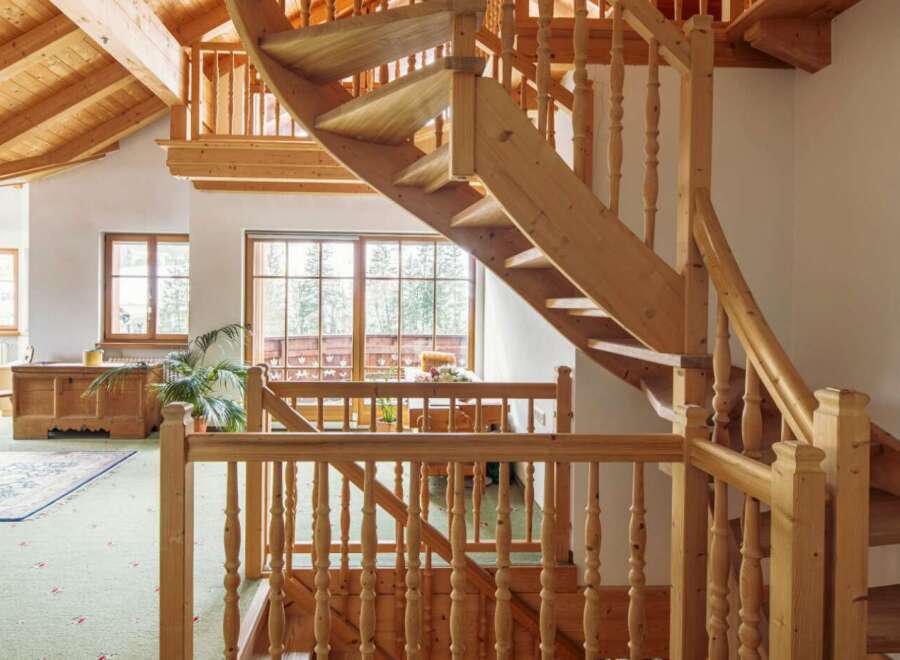 This stunning property boasts a unique, curved wooden staircase that is both functional and aesthetically pleasing.