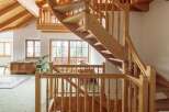 This stunning property boasts a unique, curved wooden staircase that is both functional and aesthetically pleasing.